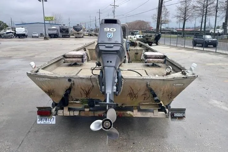 Slide: The Image of 2004 Xpress XP18CC boat with outboard motor, parked on a trailer in a lot. - 10