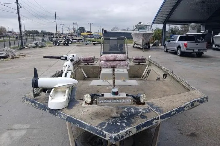 Slide: The Image of 2004 Xpress XP18CC boat with trolling motor and weathered exterior in a parking lot. - 6