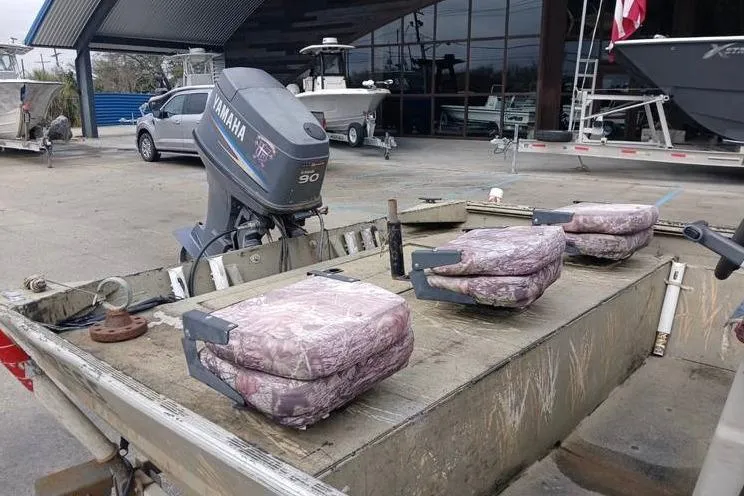 Slide: The Image of 2004 Xpress XP18CC boat with Yamaha 90 outboard motor, camo seats, parked outdoors. - 7