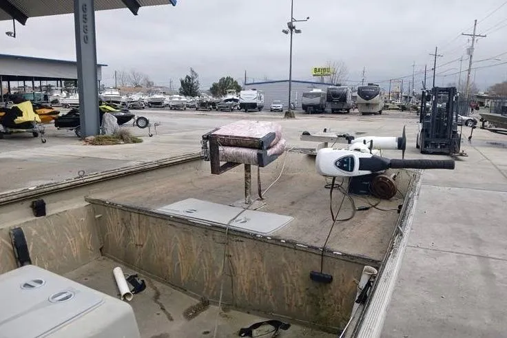 Slide: The Image of 2004 Xpress XP18CC boat in a marina, featuring a trolling motor and open deck. - 9