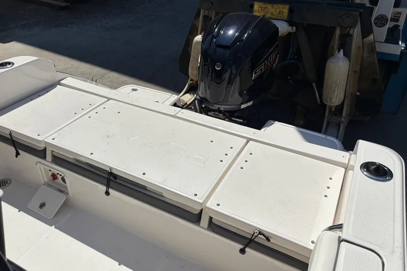 Slide: The Image of 2022 Robalo R230 Center Console boat seating area with white cushioned seats. - 11