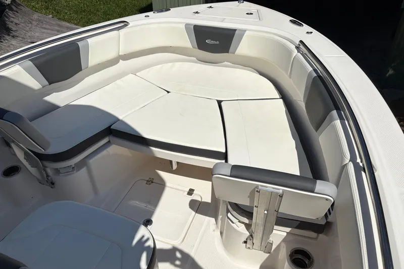 Slide: The Image of 2022 Robalo R230 Center Console T-top with rod holders, under clear blue sky. - 5
