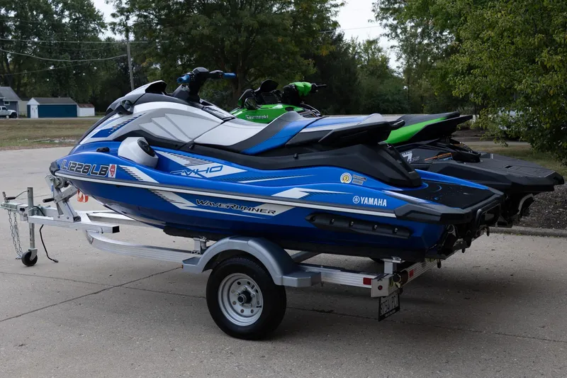 Slide: The Image of 2023 Kawasaki Jetski Ultra 310LX-S and Yamaha Waverunner on trailer, parked outdoors. - 4