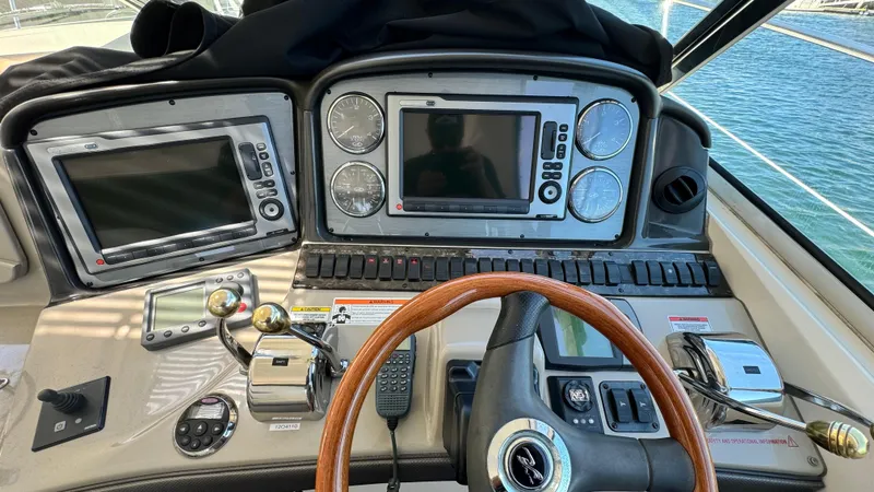 Slide: The Image of 2007 Sea Ray 44 Sundancer helm with dual navigation screens and wooden steering wheel. - 11