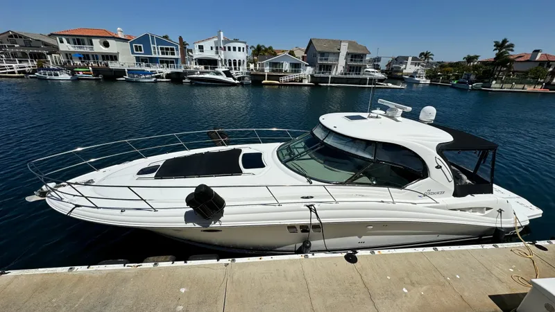 Slide: The Image of 2007 Sea Ray 44 Sundancer yacht docked in a scenic marina with waterfront homes. - 16