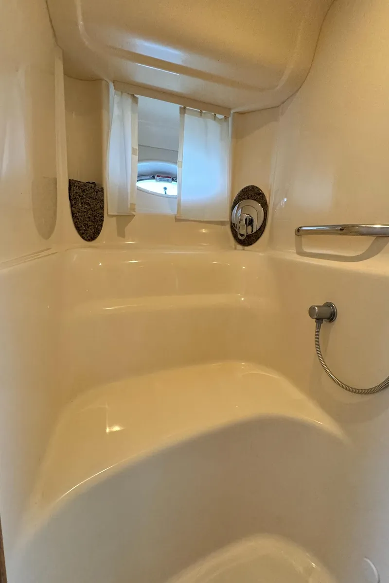 Slide: The Image of 2007 Sea Ray 44 Sundancer shower interior with built-in seat and handheld showerhead. - 18