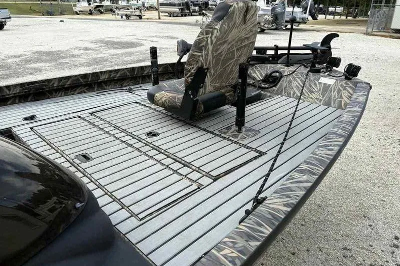 Slide: The Image of 2016 Lowe Stinger 175C fishing boat with camo seating and deck, parked outdoors. - 14