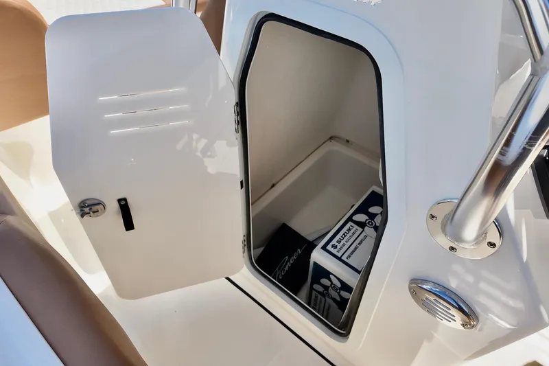 Slide: The Image of Open storage compartment on 2026 Pioneer 202 Sportfish boat, featuring Suzuki accessories. - 6