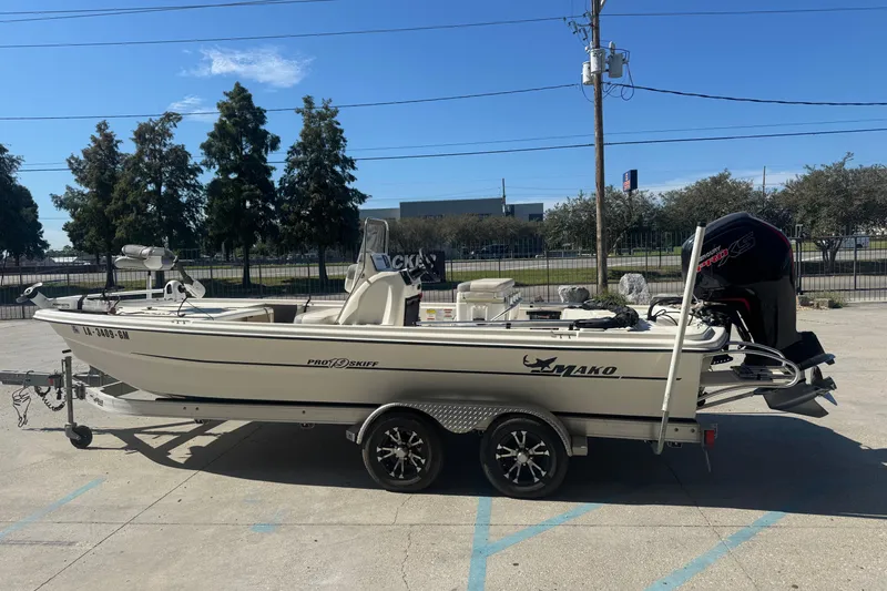 Slide: The Image of 2021 Mako Pro Skiff 19 CC boat on trailer, parked outdoors under clear sky. - 6
