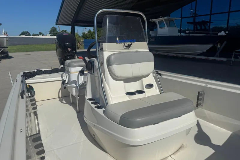 Slide: The Image of 2021 Mako Pro Skiff 19 CC boat with seating and console, parked outdoors. - 9