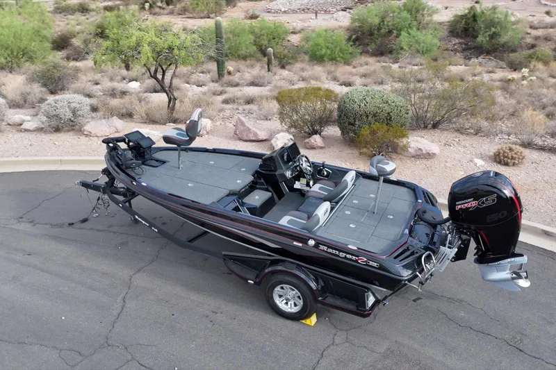 Slide: The Image of 2024 Ranger Z518 boat parked on a road, surrounded by desert landscape. - 22