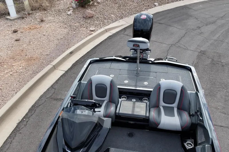 Slide: The Image of 2024 Ranger Z518 boat interior with dual seats and motor, parked on a paved road. - 4