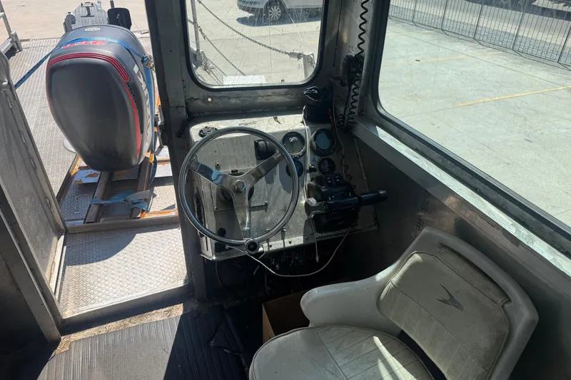 Slide: The Image of Interior of a 2010 Custom Aluminum Work Boat 33, featuring steering wheel and controls. - 12