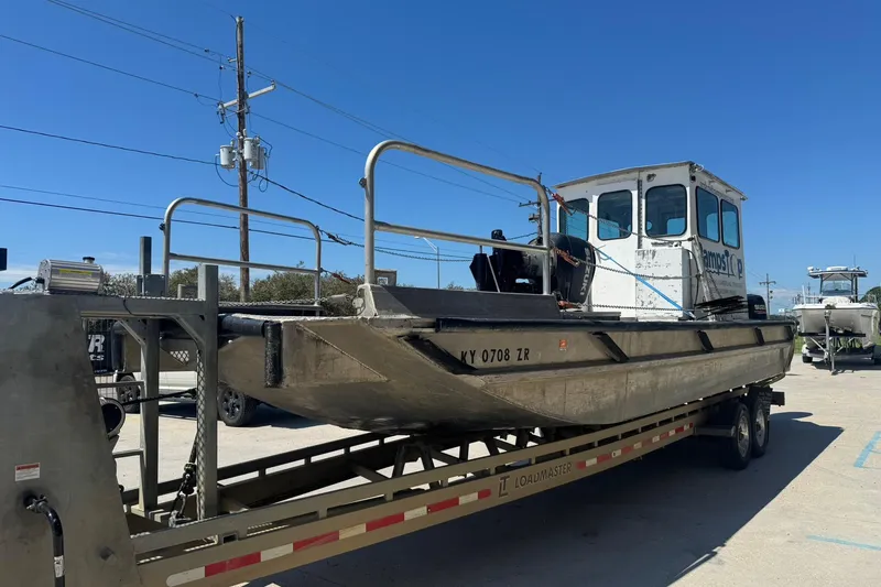 Slide: The Image of Custom Aluminum Work Boat 33, 2010 model, on a trailer under clear blue sky. - 3