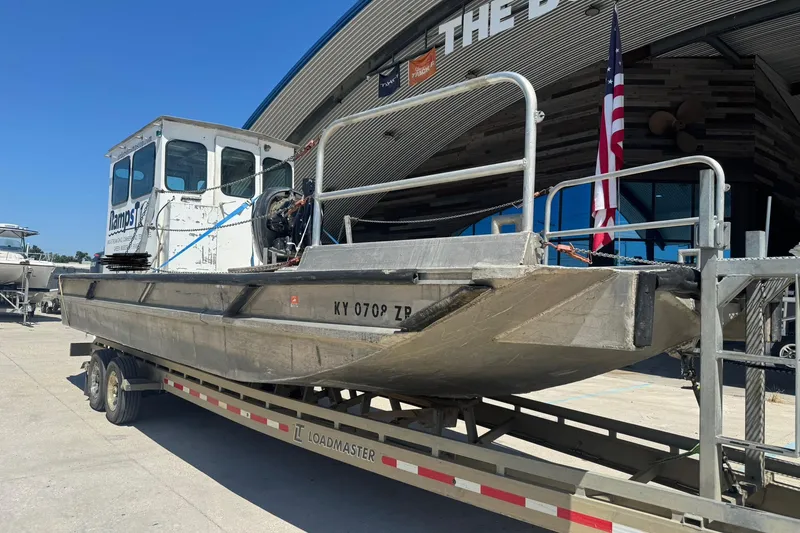 Slide: The Image of Custom Aluminum Work Boat 33, 2010 model, on trailer outside a building with American flag. - 5