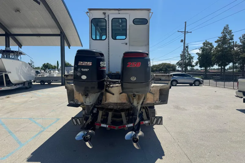 Slide: The Image of Custom Aluminum Work Boat 33, 2010 model, with dual outboard motors in a parking area. - 8