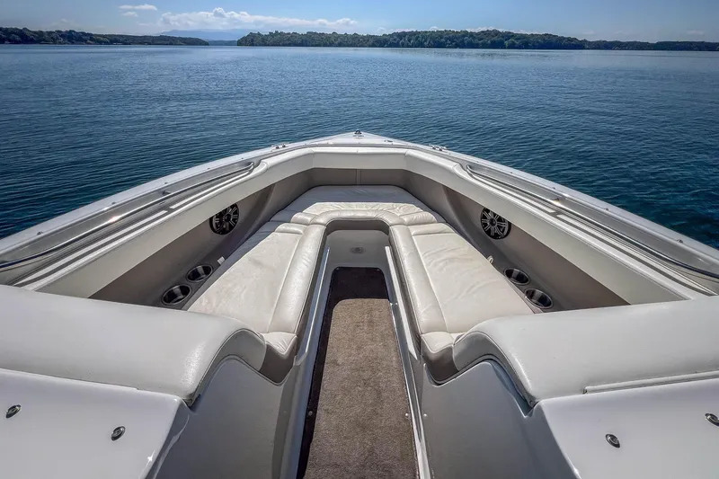 Slide: The Image of 2003 Cobalt 240 boat interior with white seating, on a calm lake. - 12