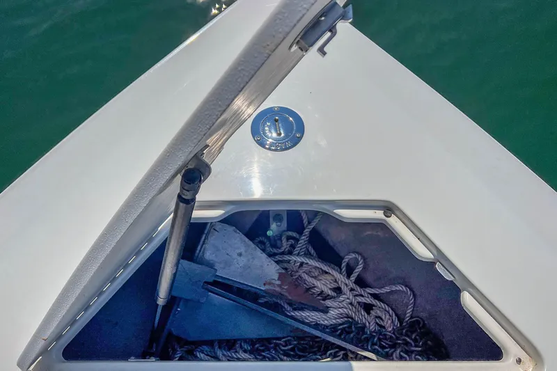 Slide: The Image of Open anchor compartment on 2003 Cobalt 240 boat, showing ropes and anchor. - 14