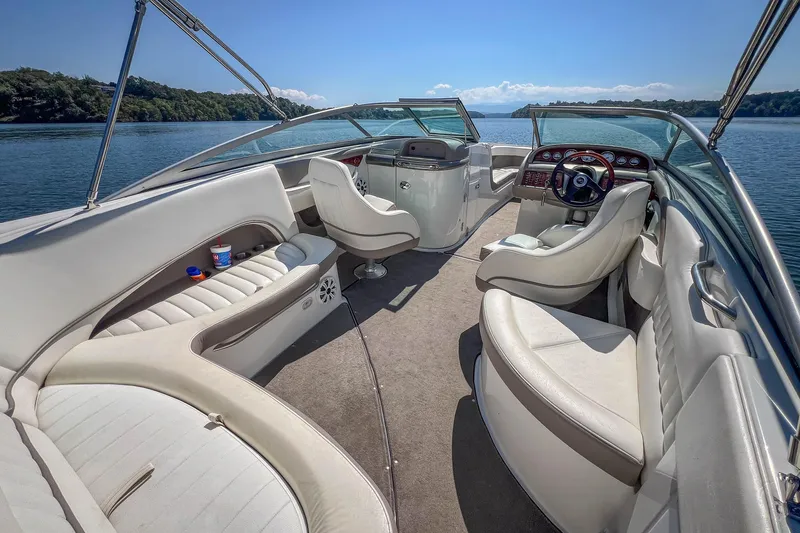 Slide: The Image of 2003 Cobalt 240 boat interior with white seating, steering wheel, and lake view. - 18