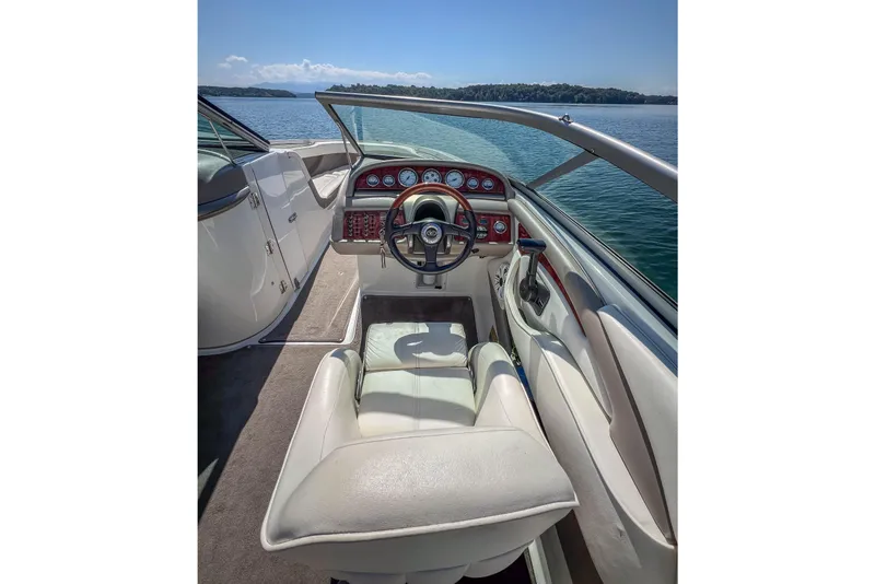 Slide: The Image of 2003 Cobalt 240 boat interior with steering wheel, dashboard, and lake view. - 21