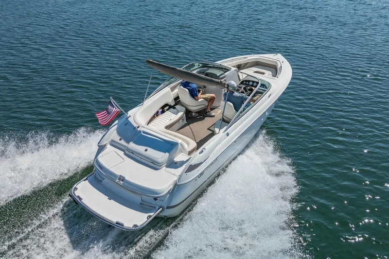 Slide: The Image of 2003 Cobalt 240 boat cruising on open water with American flag. - 5