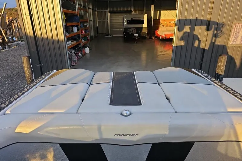 Slide: The Image of 2015 Moomba Mondo boat in a garage, showcasing rear seating and storage area. - 11