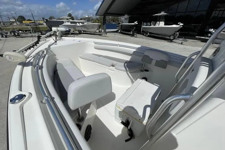 Slide: The Image of 2020 Mako 214 Center Console boat, spacious deck, white seating, outdoor showroom. - 15