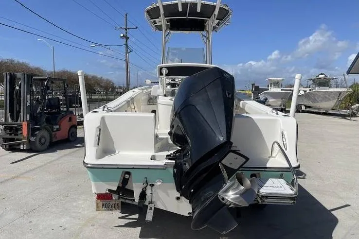 Slide: The Image of 2020 Mako 214 Center Console boat with outboard motor, docked outdoors under clear skies. - 5