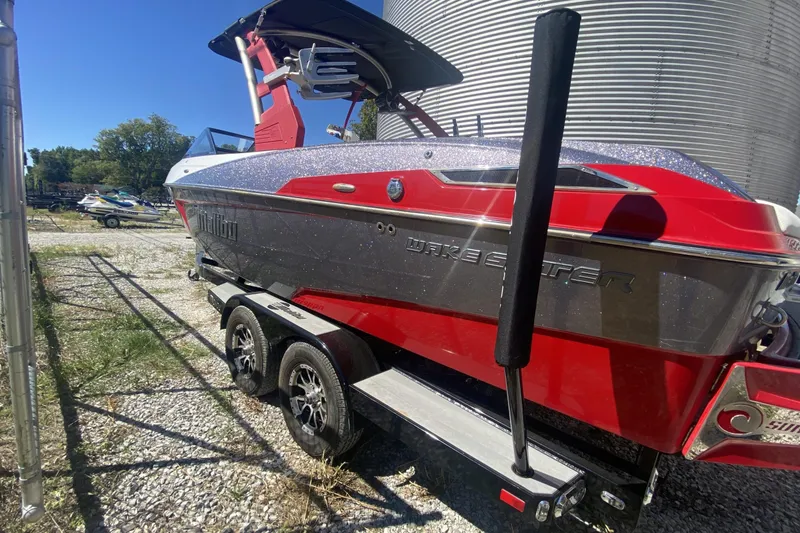 Slide: The Image of 2017 Malibu Wakesetter 23 LSV boat on trailer, red and black design, parked outdoors. - 4