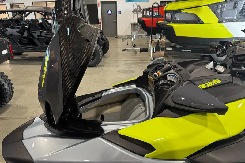 Slide: The Image of 2024 Sea-Doo RXP-X 325 jet ski with open storage compartment in showroom. - 9