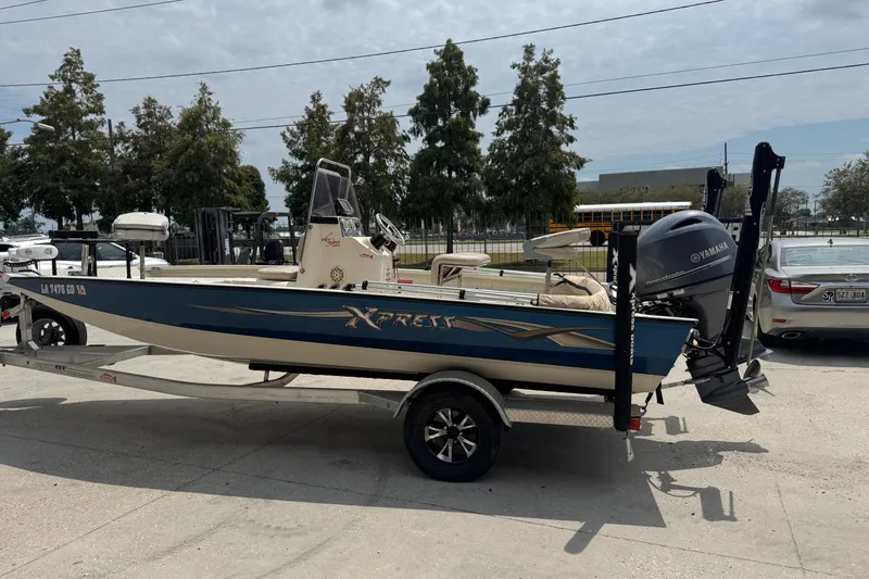 Slide: The Image of 2015 Xpress H20 boat on trailer with Yamaha outboard motor, parked outdoors. - 6
