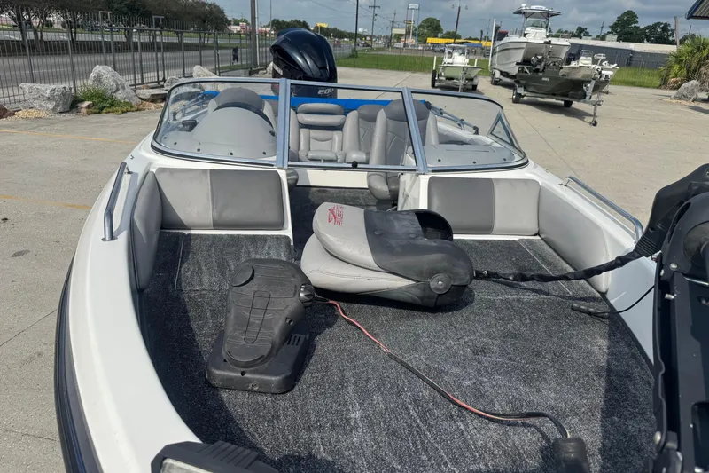 Slide: The Image of 2012 Skeeter SL210 boat interior with seating and control panel, parked outdoors. - 10