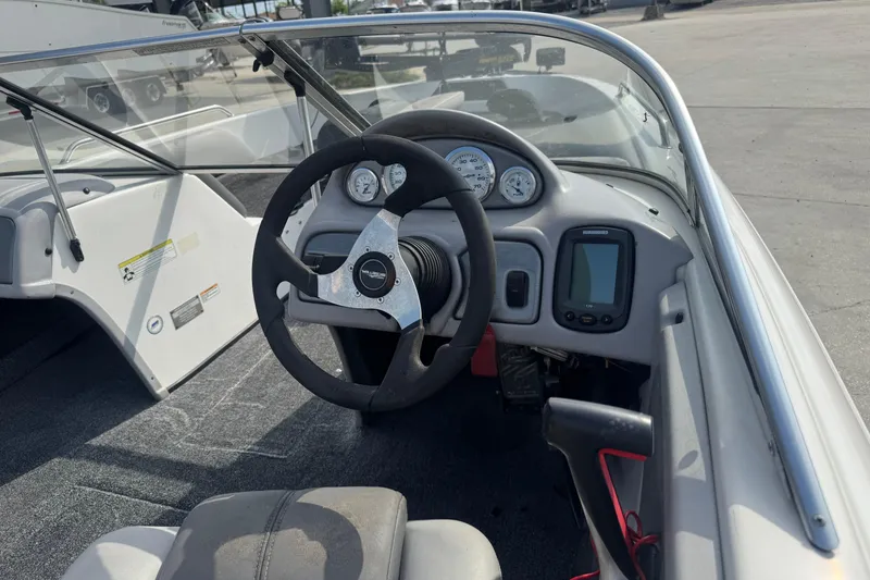 Slide: The Image of 2012 Skeeter SL210 boat cockpit with steering wheel, gauges, and navigation system. - 11
