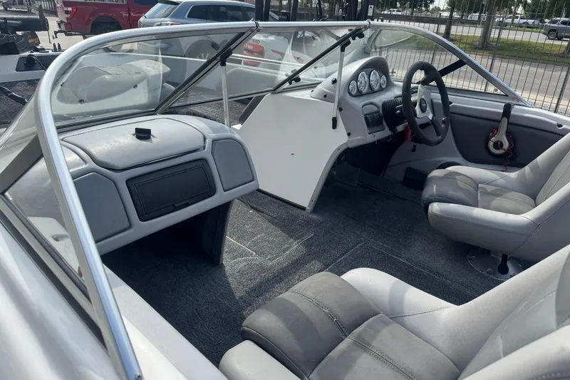 Slide: The Image of Interior of a 2012 Skeeter SL210 boat with gray seating and dashboard. - 13