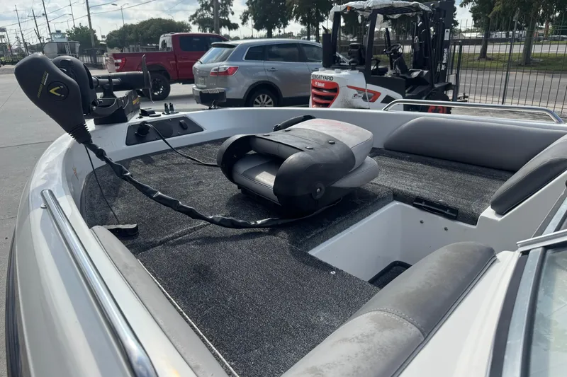 Slide: The Image of 2012 Skeeter SL210 boat interior with trolling motor and seating, parked outdoors. - 15