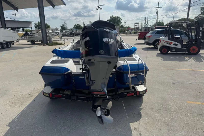Slide: The Image of 2012 Skeeter SL210 boat with Yamaha 200 engine in a parking lot. - 3