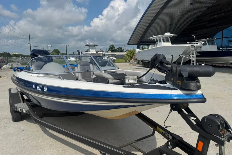 Slide: The Image of 2012 Skeeter SL210 boat on trailer, parked outdoors under a cloudy sky. - 6