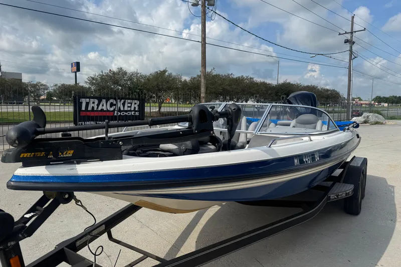 Slide: The Image of 2012 Skeeter SL210 boat on trailer, parked outdoors under cloudy sky. - 8
