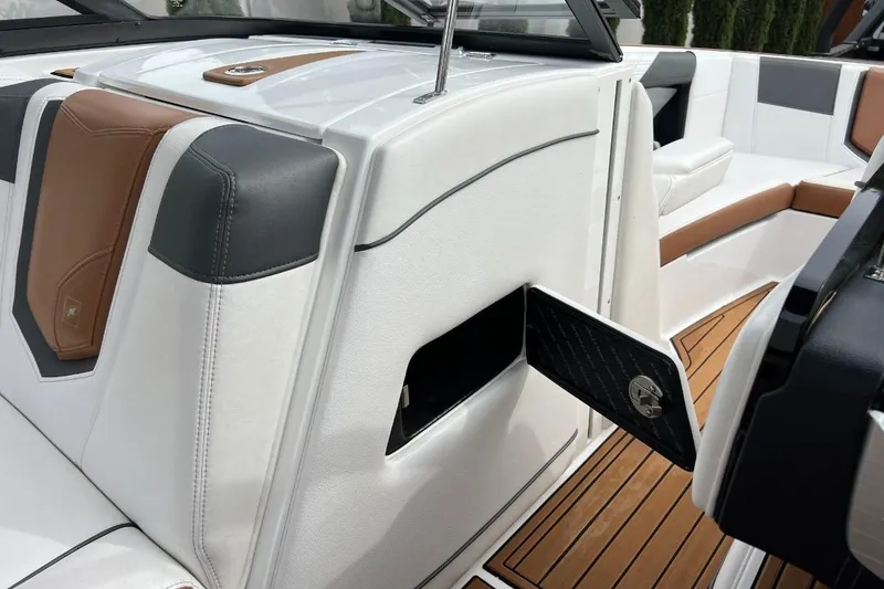 Slide: The Image of 2018 Nautique Super Air Nautique G23 interior with white and brown seating, open storage compartment. - 3