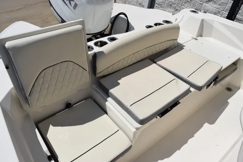 Slide: The Image of 2024 Stingray 216 CC boat interior with cushioned seating and cup holders. - 11
