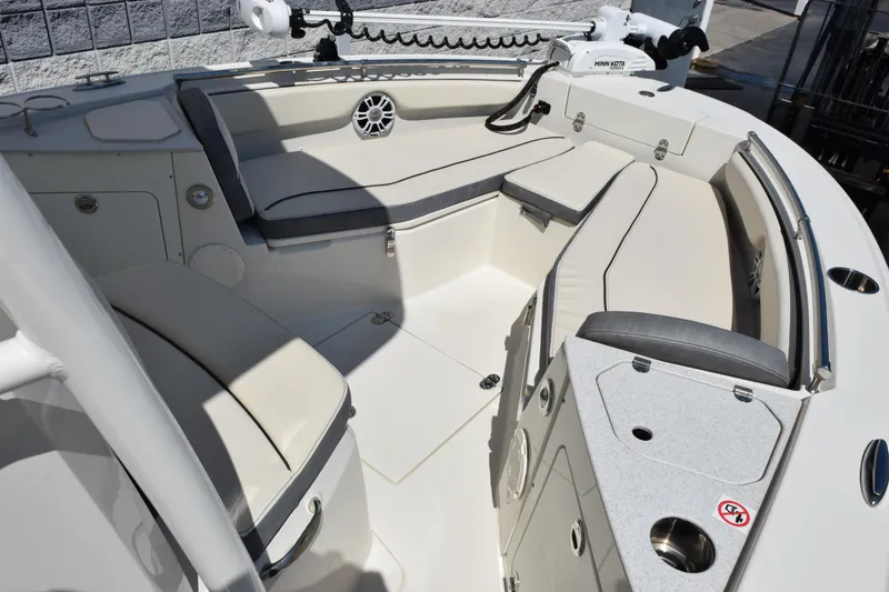 Slide: The Image of 2024 Stingray 216 CC boat interior with cushioned seating and modern design. - 12