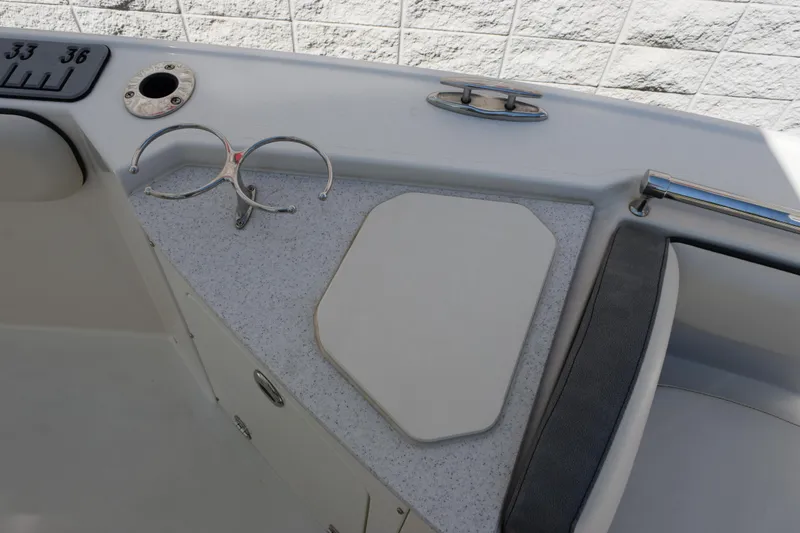 Slide: The Image of 2024 Stingray 216 CC boat interior with cup holder and seating detail. - 16