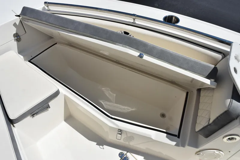 Slide: The Image of 2024 Stingray 216 CC boat storage compartment with open lid, showcasing spacious interior. - 17