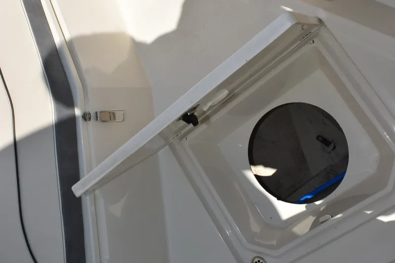 Slide: The Image of Open hatch on 2024 Stingray 216 CC boat, showcasing storage compartment. - 19