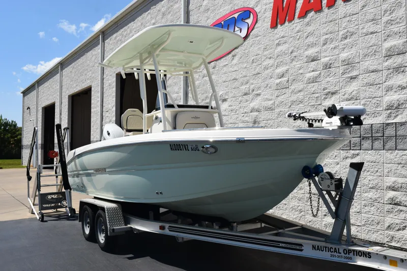 Slide: The Image of 2024 Stingray 216 CC boat on trailer outside a marine dealership. - 2