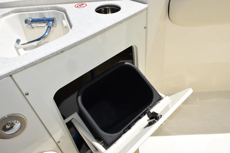 Slide: The Image of 2024 Stingray 216 CC boat interior with sink and storage compartment. - 23