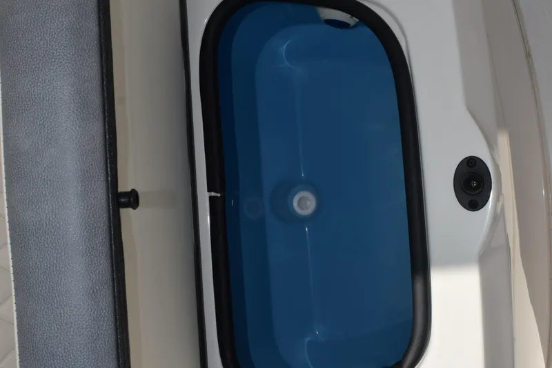 Slide: The Image of 2024 Stingray 216 CC boat livewell with blue interior and white exterior. - 24