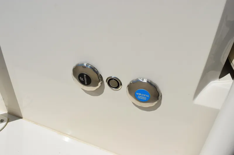 Slide: The Image of 2024 Stingray 216 CC boat waste and water access caps. - 28