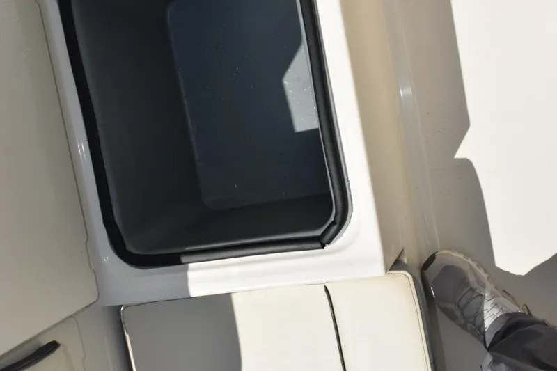 Slide: The Image of 2024 Stingray 216 CC boat interior with storage compartment and foot visible. - 30