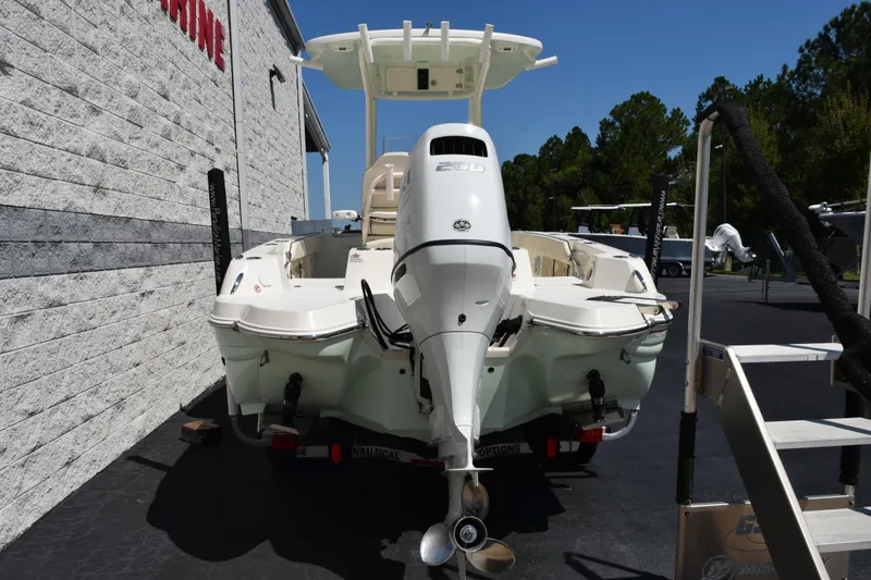 Slide: The Image of 2024 Stingray 216 CC boat with outboard motor, parked outdoors on a sunny day. - 5